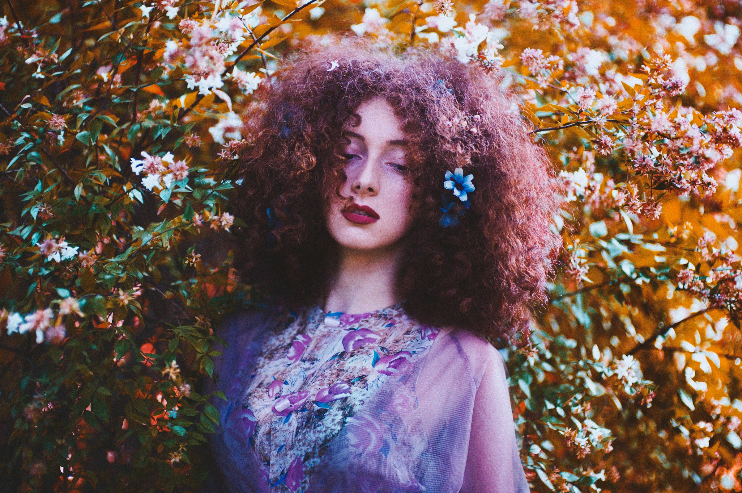 a model posing in front of flowers