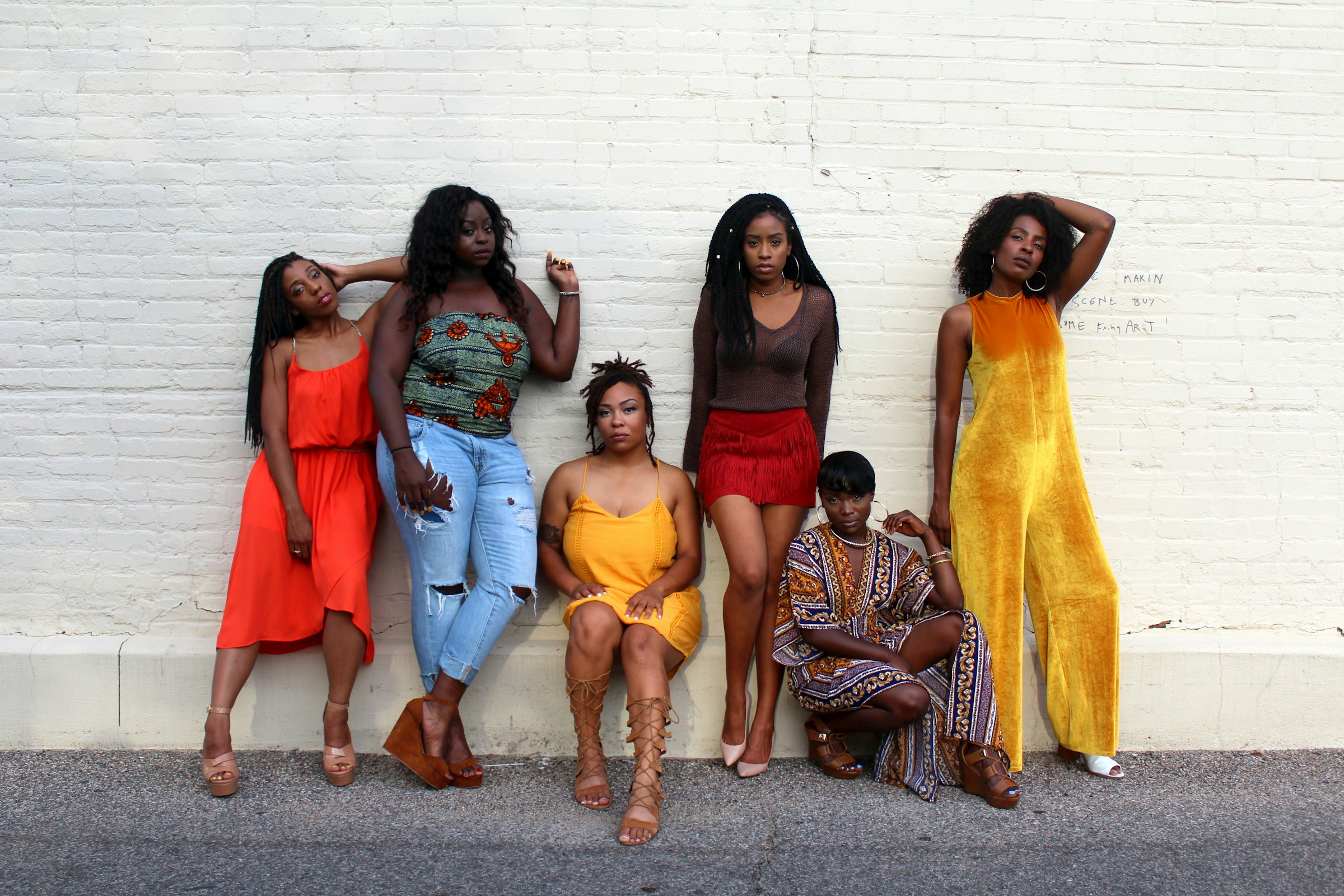 six clothing influencers posing in front of a white wall