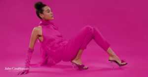 A model in pink posing for a photo in front of a pink background