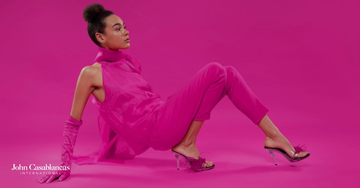 A model in pink posing for a photo in front of a pink background